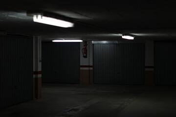 Lights on in an underground garage. Tube lights on in an underground garage with closed parking spaces. 