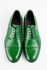 Detail pair of men's shoes of green color on a white background.