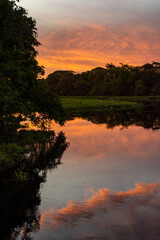 Beautiful view to orange sunset clouds over lake