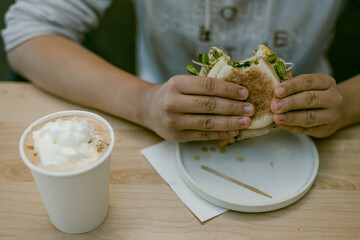 hands holding half eaten breakfast sandwich