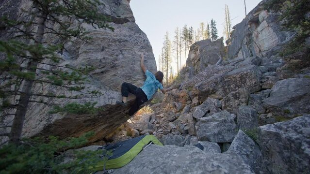 Rock climber climbs arete of boulder, bouldering