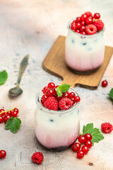 Raspberry dessert cheesecake, trifle, mouse in a glass. Raspberry Greek yogurt granola parfait on a light background. Restaurant menu, dieting, cookbook recipe