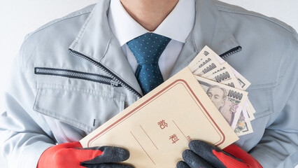 作業服の男性と日本語の給料袋