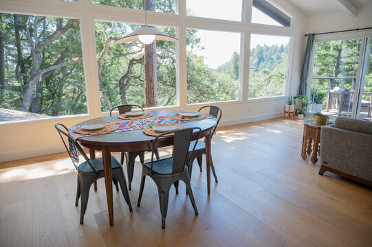 Dining room set for four with view of trees out large windows