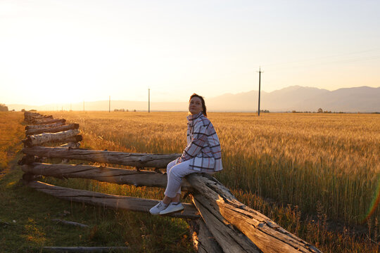 A woman in a field at sunset, Eastern Sayan Mountains, Buryatia