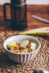Homemade Granola with Fresh Sliced Pear, Raisins and Milk in Bowl