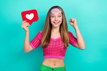 Photo of funny lucky school girl dressed pink crop top rising fist holding heart feedback isolated...