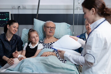 Nursing student doing internship with elderly senior at geriatric hospital. Female health...