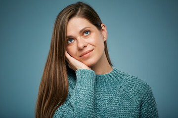 Fototapeta premium Smiling woman touching face and looking up. Isolated female face close up portrait