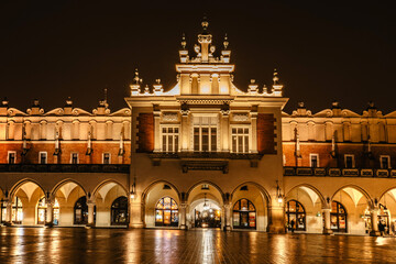 Obraz premium Illuminated Krakow Cloth Hall, Polish Sukiennice on main market square,Poland.Renaissance building at night during Christas.Evening city lights.Festive atmosphere.Historic center of Krakow.UNESCO site