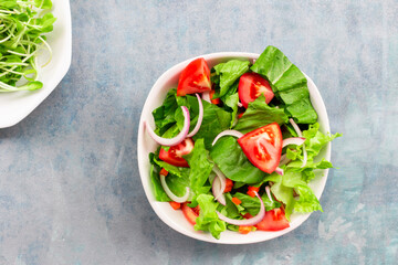 Healthy food leave lettuce vegetable salad has tomato in bowl on blue wood background.