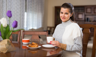 Obraz na płótnie Canvas Portrait of elegant woman is posing with tea at home. High quality photo