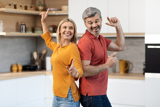 Joyful middle aged man and woman having fun at home