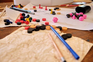 Role paying game table mid campaign. Pink and black dice, hand drawn maps, papers, pencils, and...
