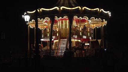 Beautiful illuminated carousel details during the round of the Christmas market. Vintage colorful carousel
