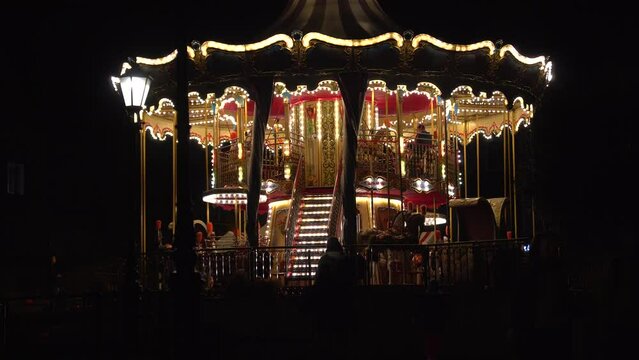 Beautiful illuminated carousel details during the round of the Christmas market. Vintage colorful carousel