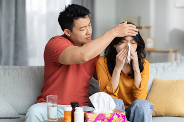Loving asian man husband taking care of his sick wife