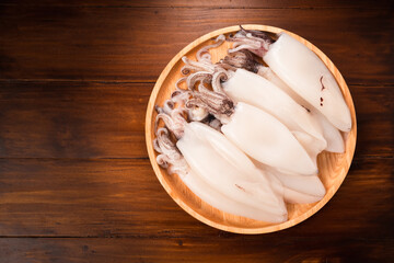 Fresh Squid in wooden plate on wooden background, Fresh Splendid Squid on wooden plate.