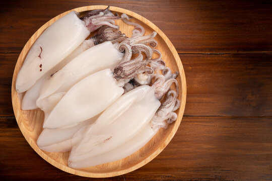 Fresh Squid in wooden plate on wooden background, Fresh Splendid Squid on wooden plate.