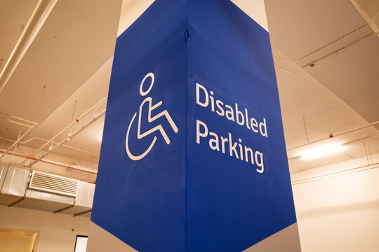 A disabled parking sign painted on a building column