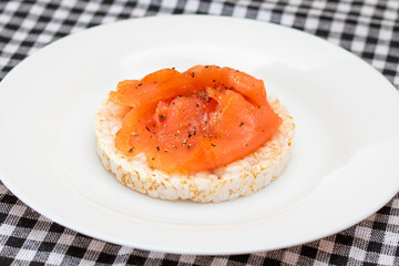 Tasty Rice Cake Sandwich with Fresh Salmon Slices on White Plate. Easy Breakfast and Diet Food....