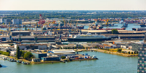 Aerial view of Rotterdam seaport territory overlooking docks and harbour-basins with cargo cranes...