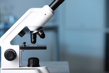 Modern medical microscope against blurred background, closeup. Space for text