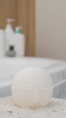 Bath bomb and sea salt on table in bathroom