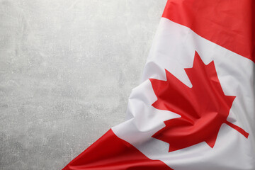 Flag of Canada on light grey stone table, top view. Space for text