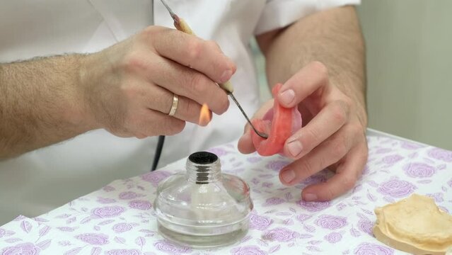 Dental technician making removable dentures. Manufacturing process of removable dentures in dental clinic. Production of removable denture. Prosthetic dentistry. Close up