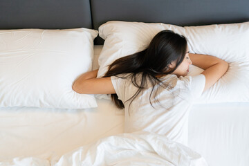 Beautiful young Asian woman sleep in the bed at home. Top view, copy space