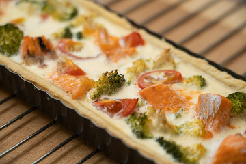 Ready-made quiche with salmon, broccoli and tomatoes. Cooking a pie.