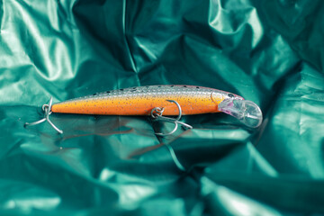 fake fish bait for fishing with a green background with a folded texture