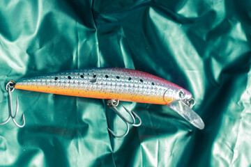 fake fish bait for fishing with a green background with a folded texture
