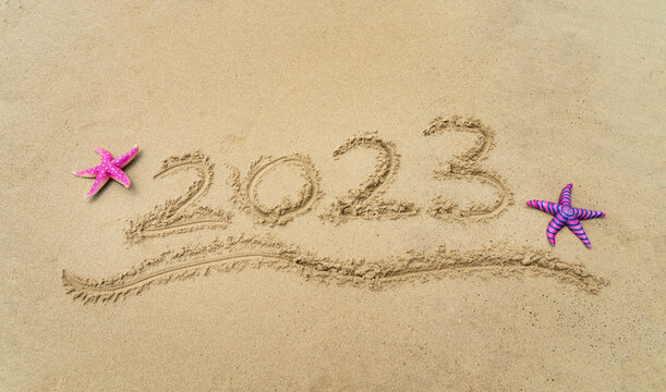 2023 handwritten with starfish in sand on a beautiful beach