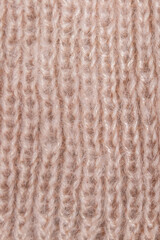 Background from gently pink woolen knitted threads. Hobby manual labor. Space for text. Close-up. Vertical.