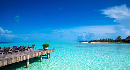 Fototapeta na wymiar tropical beach in Maldives with few palm trees and blue lagoon.