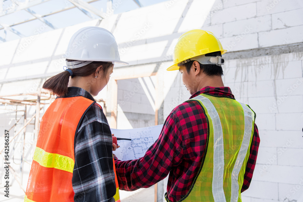Poster architect and client discussing the plan with blueprint of the building at construction site. asian 