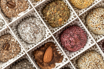 Candies in a white box made of dried fruits, without sugar and dyes. From natural ingredients. Contains dates, coconut, dried apricots, almonds, peanuts, figs, sesame and cocoa.