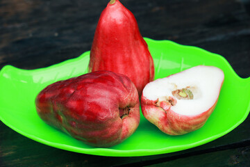 sour water guava on a green plate on a wooden table