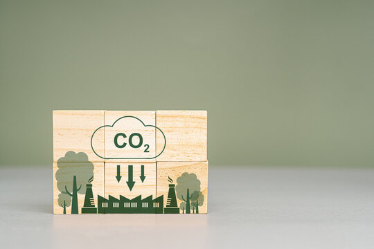 Wooden cubes with CO2 and green tree icons with the world map. Net-Zero Carbon Emissions by 2050