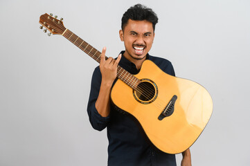Obraz premium Portrait of Young Asian man playing an acoustic guitar isolated on white background