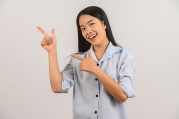 Portrait of young asian woman pointing with two hands and fingers to the side over isolated white background