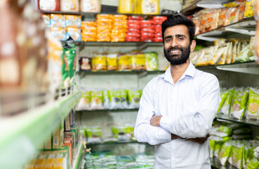 portrait of  smiling indian male in grocery with pointing toward the product 