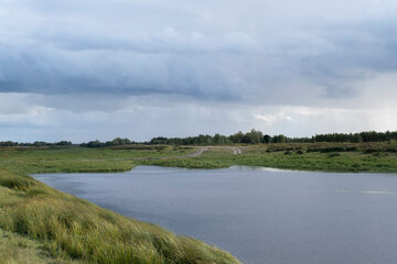 Beautiful natural landscape of a forest lake and blue sky with clouds.