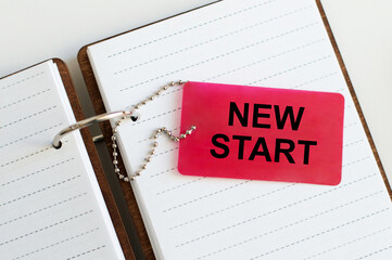 New Start text on a red card on an open notebook on a light background
