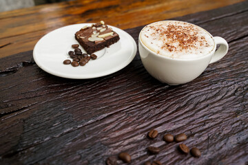 Hot cappuccino in white cup with wooden background,coffee is a popular drink all over the world.