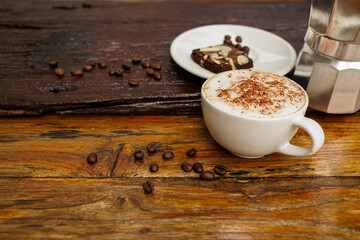 Hot cappuccino in white cup with wooden background,coffee is a popular drink all over the world.
