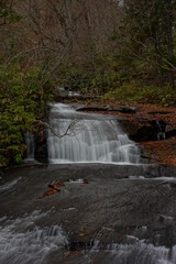 落葉の横を流れる恵庭渓流のラルマナイの滝