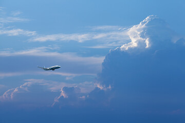 Airplane flying high and approaching an area of ​​very high clouds.